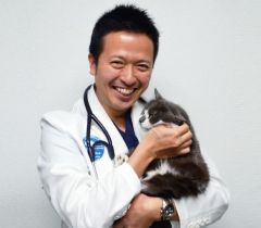 佐藤先生が猫を抱いて笑っている画像